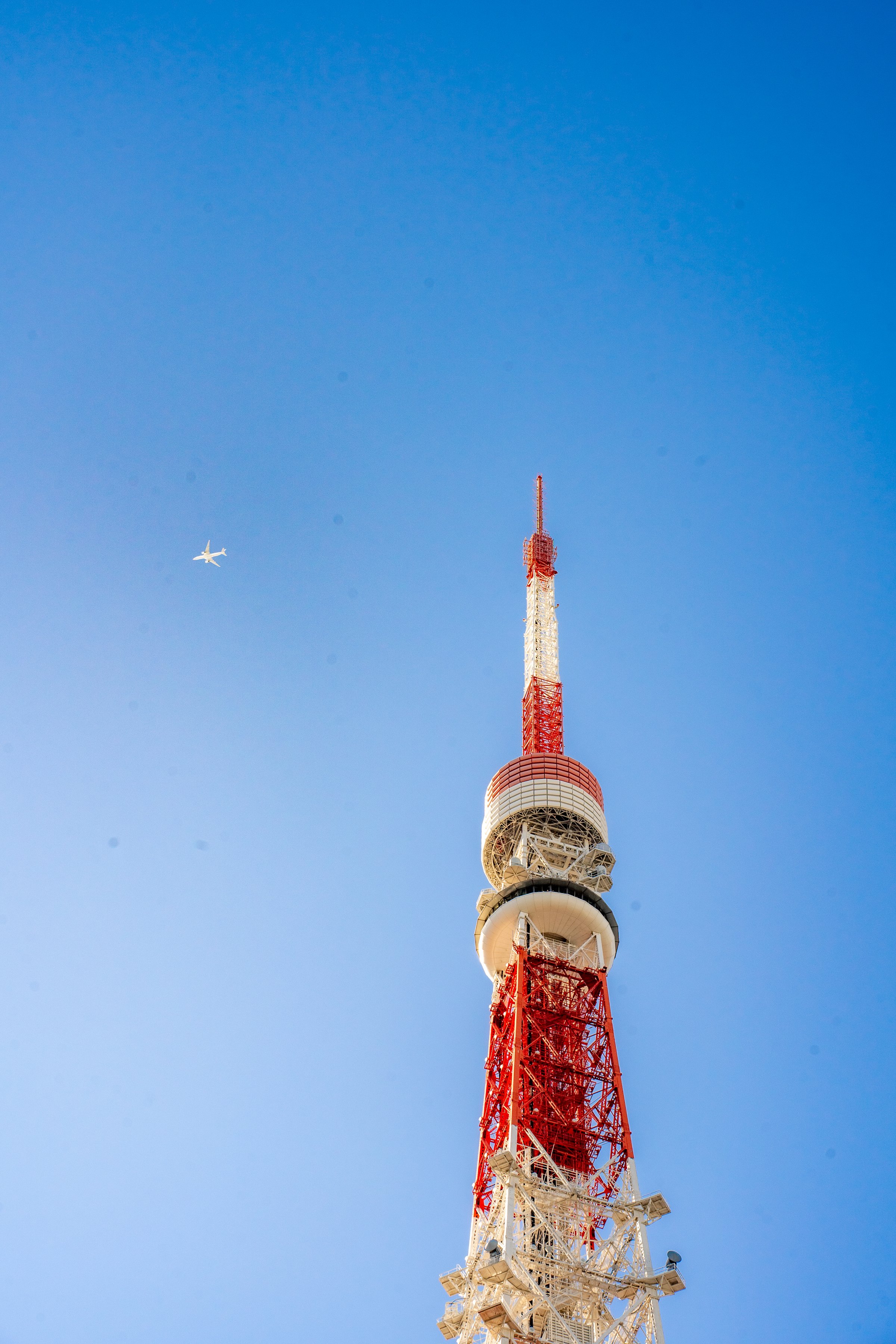 Tokyo Tower against blue sky with airplane